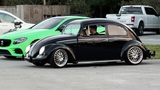 Carpet - a man driving a black volkswagen beetle | Trending HD Video