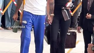 hand-in-hand they arrive at the airport to jet out