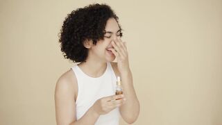 Woman Within - a woman laughing with a bottle of essential oil on hand | Trending HD Video 2