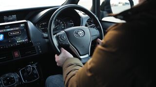 Carpet - person holding steering wheel in toyota car | Trending HD Video