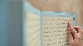 close up of a hand pointing at a koran | Professional HD Video
