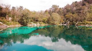 Silly Smile Live Wallpaper 4K - serene lake with turquoise waters and forested surroundings | T