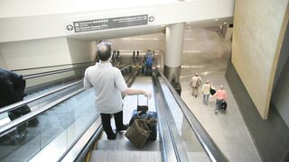 Travelon - man on escalator at airport | Trending HD Video