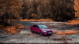 Cartier - drone shot of black and red car near trees | Trending HD Video