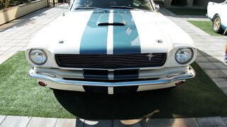 Electric car - close up footage of the front end of a parked classic mustang car with striped h