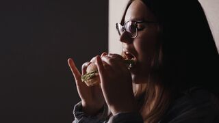 Woman - woman wearing eyeglasses eating a burger | Trending HD Video