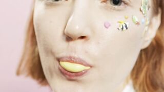 The Shy Snow Woman and the Cursed Ring - a woman with stickers on her face blowing bubble gum |
