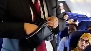A bangdeshi man is paying for a ticket inside a plane