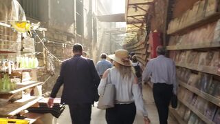Woman - woman looking curious at a stock display while walking in an alley | Trending HD Video