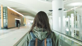 The Pioneer Woman - woman standing on a walkalator inside an airport | Trending HD Video