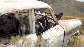 Electric car - close up video of rusty abandoned car on green grass field | Trending HD Video