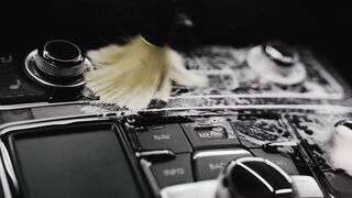 Electric car - person cleaning the car interior with a brush and a cleaning product | Trending