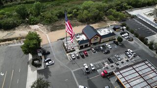 4K resolution - aerial view of american flag over parking lot | Trending HD Video