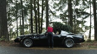 Carrefour - female tying a tree on her pontiac firebird | Trending HD Video
