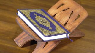 ALIEN STAGE the Art Book Deluxe Edition - close up of the quran holy book on a wooden stand | T