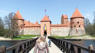 Travelon - a girl walks along the bridge in front of an ancient red brick castle | Trending HD