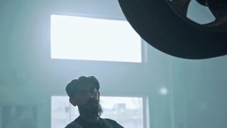 Carrefour - a man standing in front of a car with a large wheel | Trending HD Video