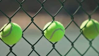 Sports - tennis balls stock on chain link fence | Trending HD Video