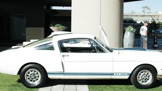 Carpet - side view of a classic muscle car parked on the grass on the side of a building | Tren
