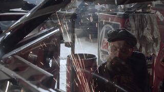 Carrefour - a man working on a car in a garage | Trending HD Video