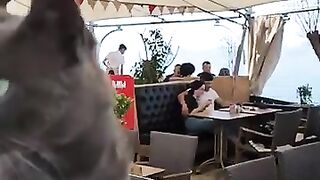 A hungry cat knows which table to go to in order to find food in a restaurant.