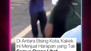 Nampak seorang kakek berjualan bunga di persimpangan jalan