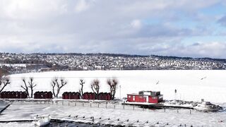 Winter solstice - aerial view of frozen river and red houseboat | Trending HD Video