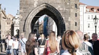 Travelpro - tourists walking through charles bridge archway | Trending HD Video
