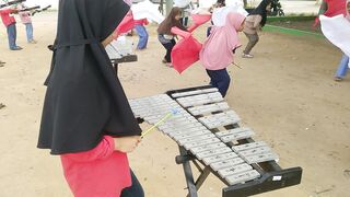 Students Playing Traditional Xylophone at Outdoor School Celebration