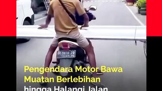 Seorang pengendara motor nekat membawa muatan berukuran panjang