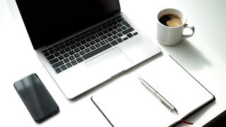 Person Writing in Notebook at Modern Minimalist Workspace