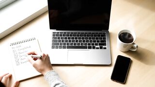 Person Writing To-Do List at Professional Workspace