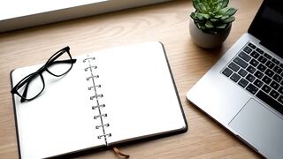 Minimalist Workspace with Blank Notebook, Laptop and Glasses on Wooden Desk