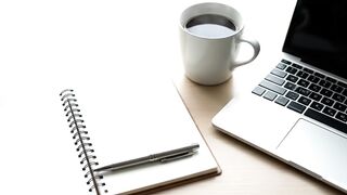Minimalist Workspace with Laptop Open Notebook and Coffee Cup