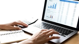 Financial Data Analysis on Laptop with Calculator and Notebook