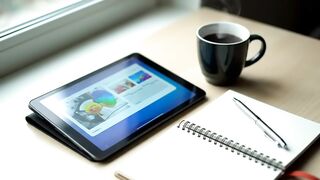 Modern Workspace with Digital Tablet, Coffee Cup, and Spiral Notebook