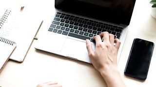 Close-Up of Hand Using Laptop Trackpad on Modern Desk