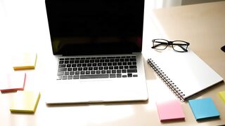 Modern Home Office Workspace with Laptop, Spiral Notebook, and Sticky Notes