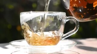 Pouring Hot Tea into Clear Glass Cup