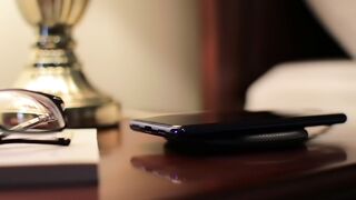 Smartphone Wirelessly Charging on Bedside Table at Night