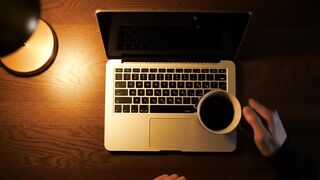 Overhead View of Laptop, Coffee, and Hands on Wooden Desk
