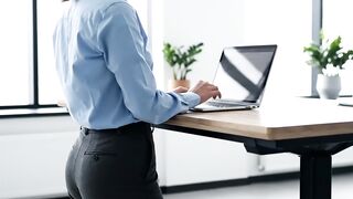 Professional Woman Working at a Height-Adjustable Standing Desk