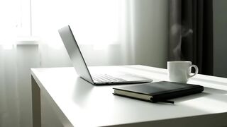 Minimalist Workspace with Laptop and Steaming Coffee