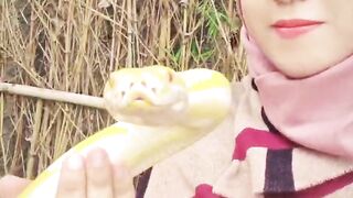 A woman is playing with a snake
