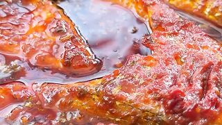 Tender sea bass fillets are simmered in a bold, spicy red sauce infused with aromatic herbs and spices.
