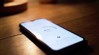 Smartphone Displaying '141 Trassseg' on Wooden Surface