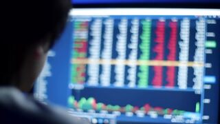 Person Monitoring Financial Data and Stock Charts on Computer Screen