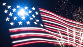 Glowing American flag made of neon lights waving against a background of bright celebratory fireworks