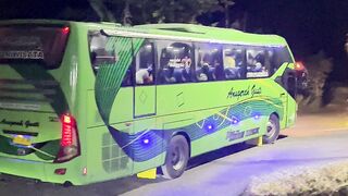Green Tour Bus Navigates a Tight Corner on a Dark Rural Road at Night