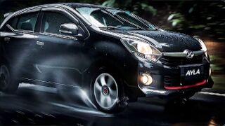 Black Daihatsu Ayla car slowing down